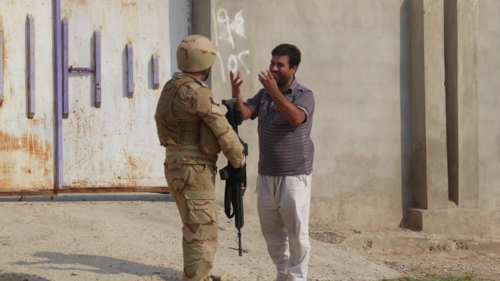 Man in Faizalia thanks a Kurd soldier.