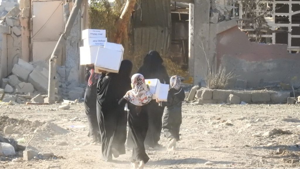 Women and children with food and hygiene supplies. Photo: FBR. 