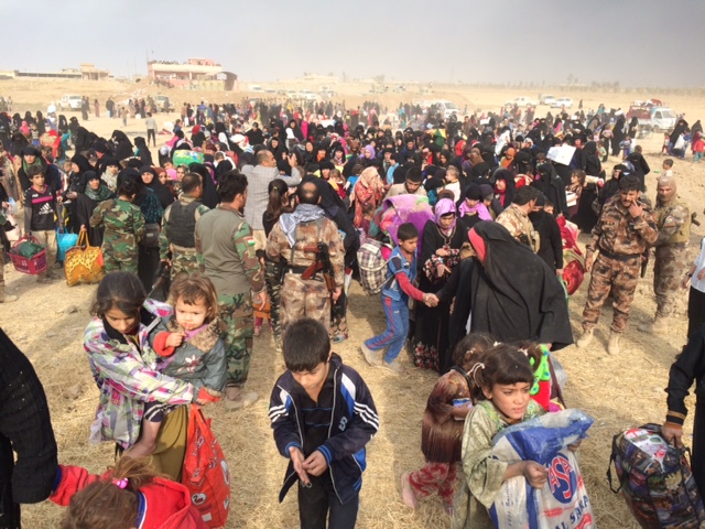 IDPs stream through the breach after being liberated from ISIS control.