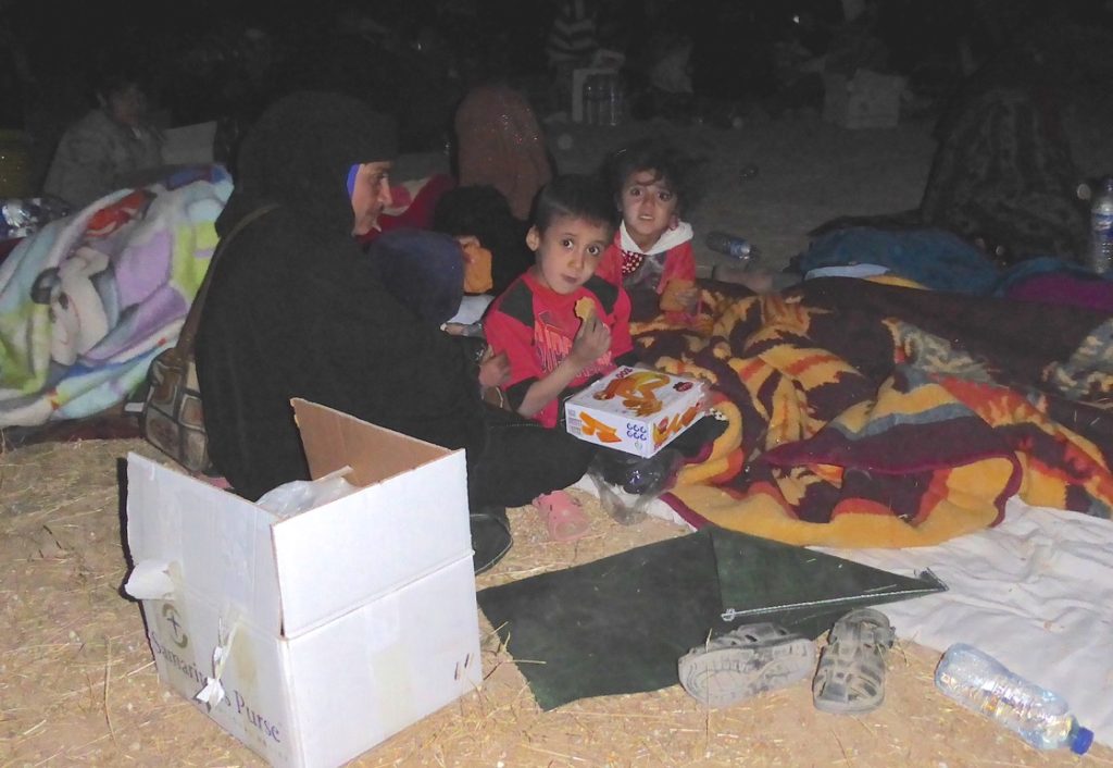 A family huddles around a distributed food box given by Samaritans Purse (SP). Photo: FBR. 
