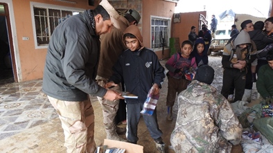 Iraqi army and team giving out clothes and picture books for the children. 