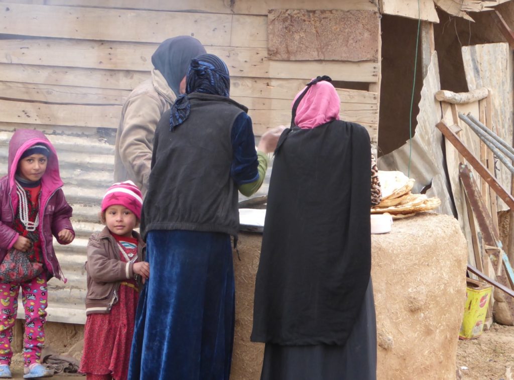 Families make bread in newly liberated neighborhood of Mosul.