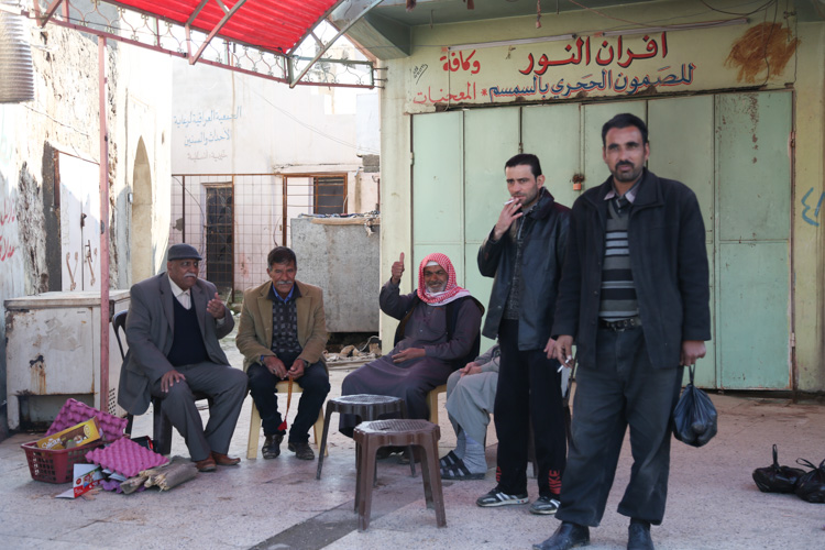 Locals sitting near market drinking tea and smoking