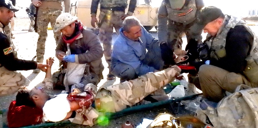 Eliya, medic from Burma, and I treat wounded Iraqi soldier in northeast Mosul