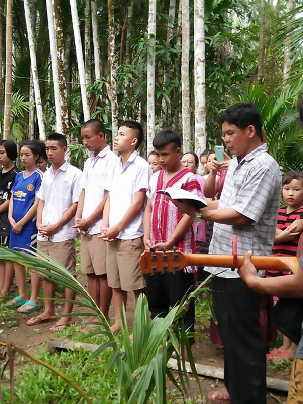 Samuel, the hostel father, reads scripture before the baptism.
