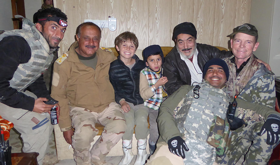 In January 2017, Shaheen (far left) help facilitate the return of a young Yazidi boy (center) to his family after being sold to an Arab family in Mosul.
