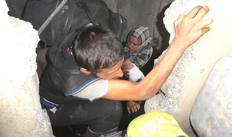Families crawling through holes in the walls to escape ISIS.