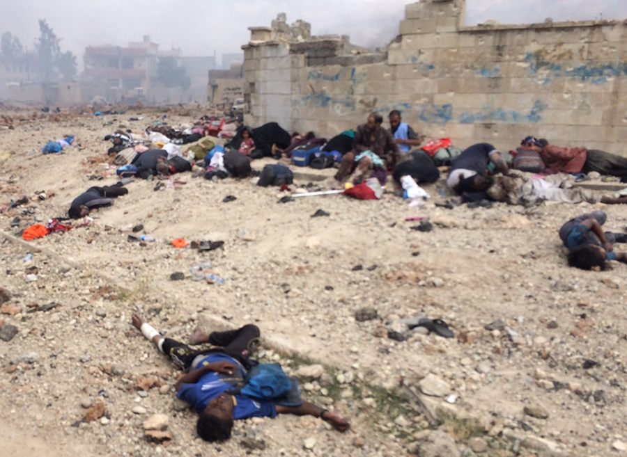 Those still living sit among the dead while waiting for help and surrounded by ISIS fire. 