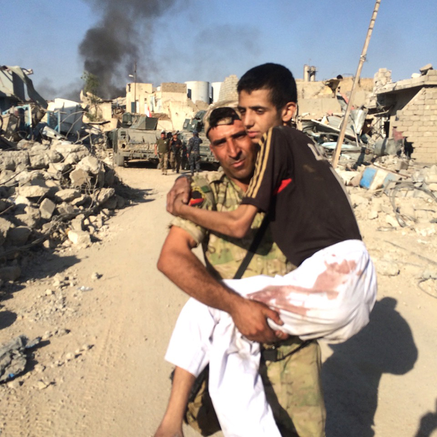 A member of the Iraqi Army carries a civilian to safety.
