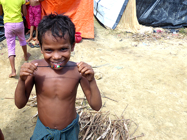 A boy holds up his new GLC bracelet.