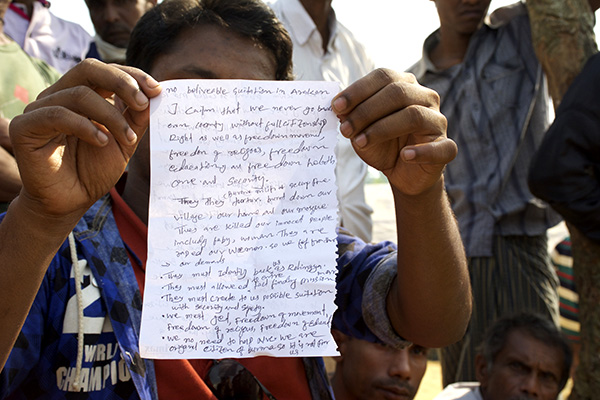 A Rohingya man holds up his written statement that outlines who they are and what they need to be able to return to Burma.