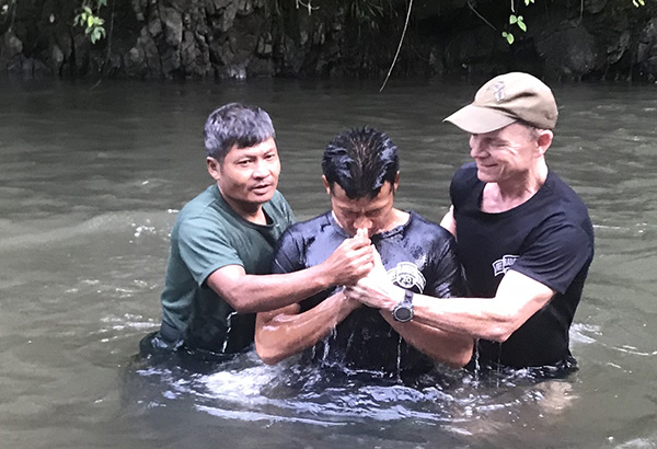 Kwee Po, center, being baptized by FBR Chaplain Monkey (left) and Dave Eubank (right).