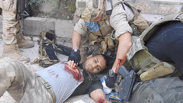 Dave working to save Lt. Hussein's life on the streets of Mosul.