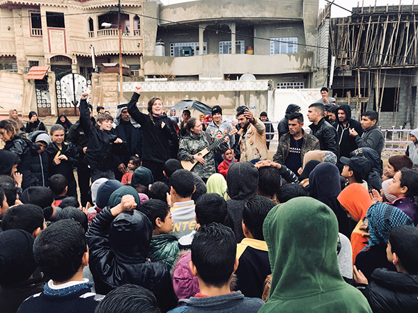 The team sings for families at a new playground in Mosul. 