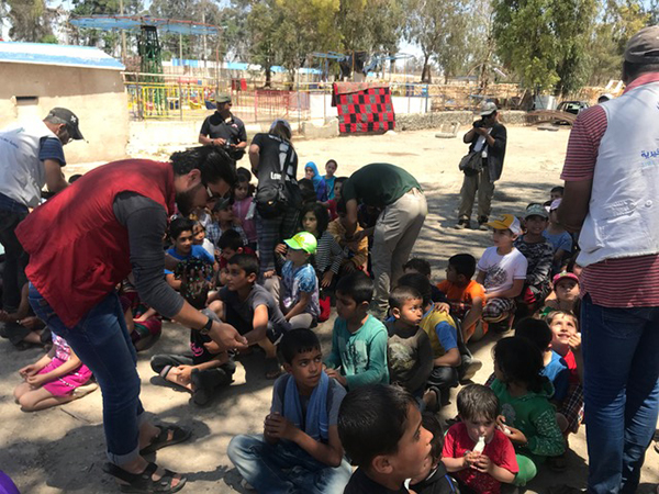 Local NGO workers help us hand out Good Life Club bracelets at the Tabqa program. 