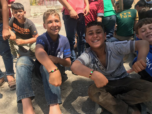 Tabqa kids show off new bracelets.