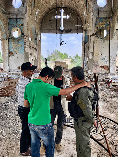 Praying in the church damaged by ISIS that now hosts Yezidis who fled Afrin.