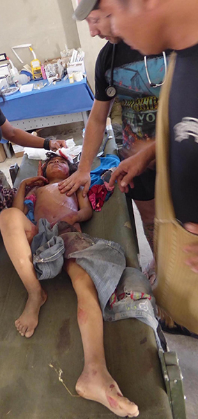 Eliya, a Karen FBR medic, and SFC Johnson work on a young patient.