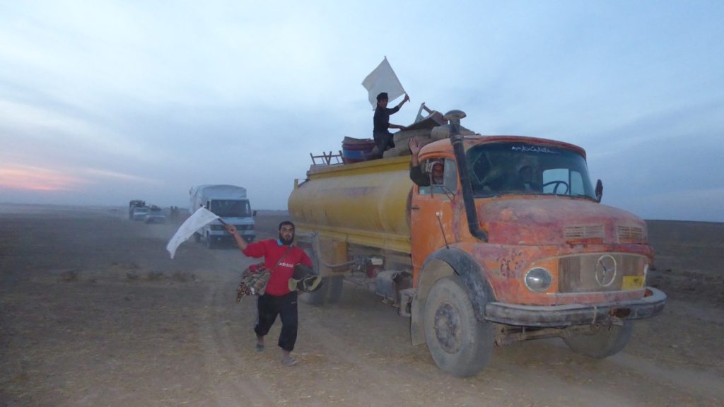 IDPs wave white flags while entering the camp. Photo: FBR.