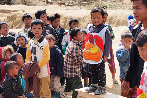 A Kachin child wears an anatomy apron during the health and hygiene portion of a GLC program.