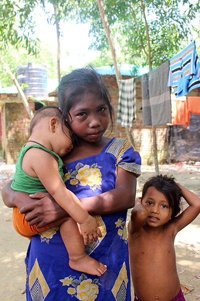 A young girl holds her baby brother who was born in the camp. Their mother fled while she was five months pregnant and their father has been missing since the day of the attack. They presume he's dead.