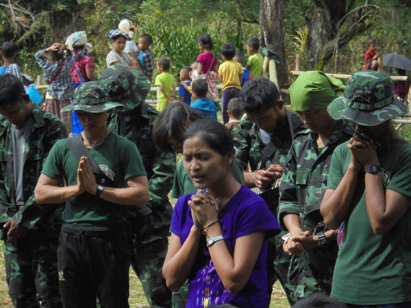 A GLC team leader prays before breaking for lunch snacks.