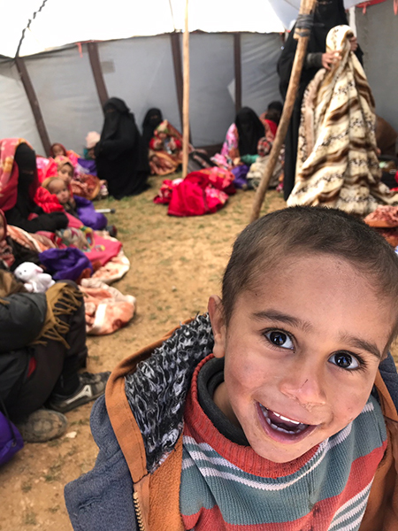 A child who fled Baghuz, now happy in a tent.