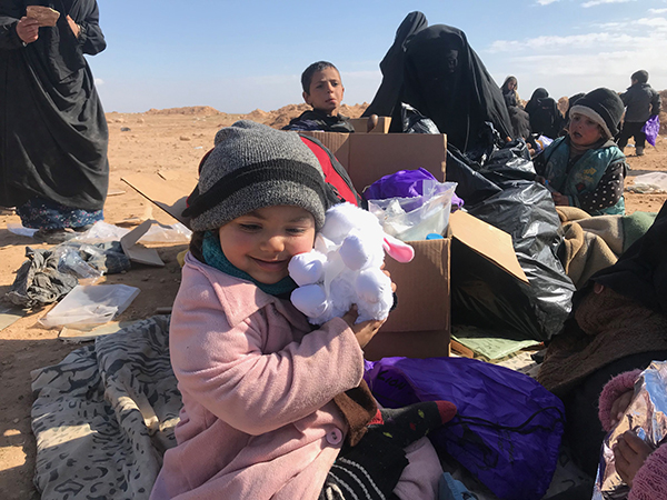 A child squeezes her new stuffed lamb from ATP Ministries.