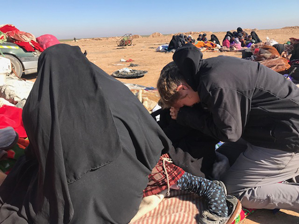 Suu cries with a girl whose sister had just died from shrapnel to the head. We could not save her.