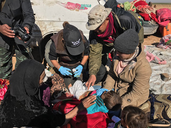 Eliya and team treat a child shot in the stomach while fleeing ISIS in eastern Syria.