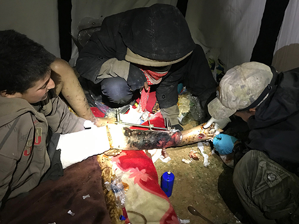 Joseph, a Karen medic, helps treat a boy wounded by the Syrian Army.