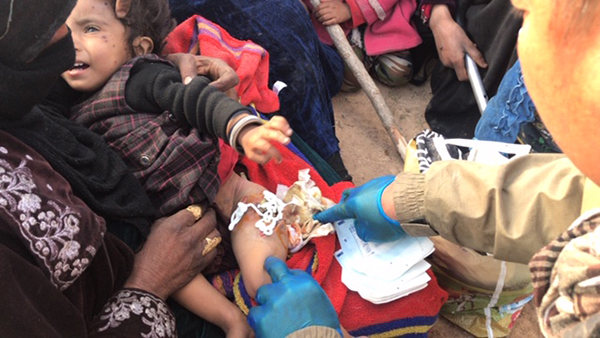 Eliya, a Karen medic, treats a child shot by ISIS