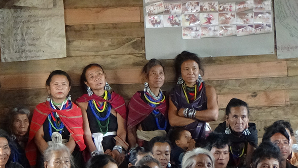 Karenni women stand at the back of a packed room during a GLC program.