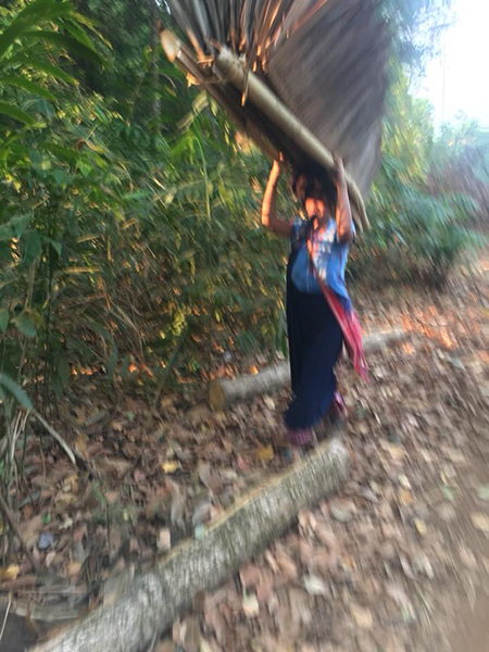 A villager from Pa Kaw Hta Village carries away part of a house into the jungle.