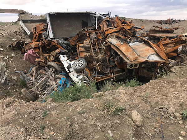 Vehicles in Baghouz that once sheltered ISIS, now in a rubble pile.