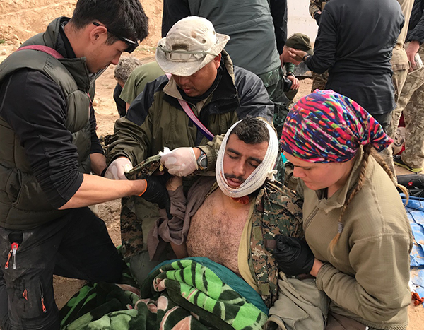 The team treats a wounded SDF soldier.