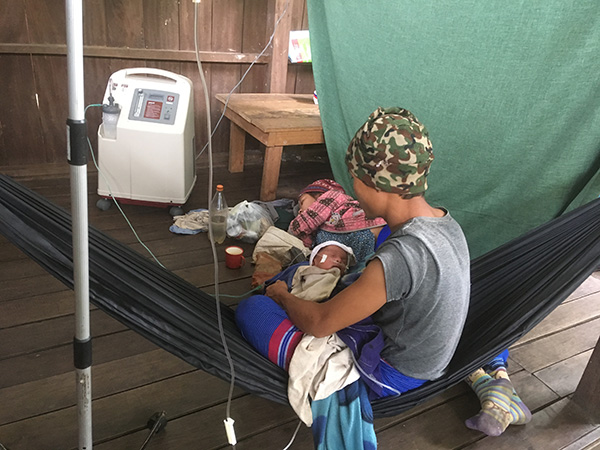 A baby with severe pneumonia uses the oxygen concentrator, now run by solar power instead of fuel.