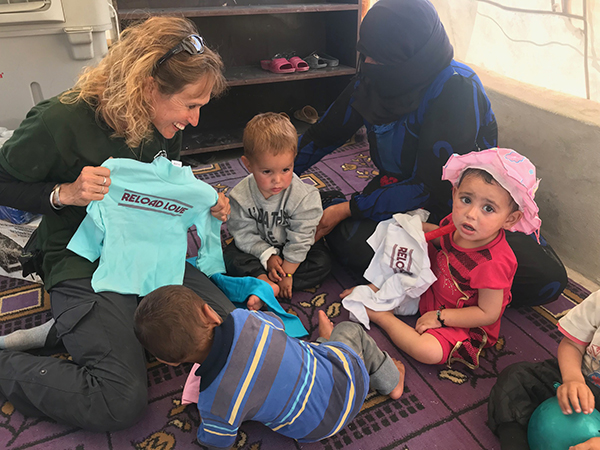 Karen Eubank given shirts from Reload Love to kids in Al-Hawl.