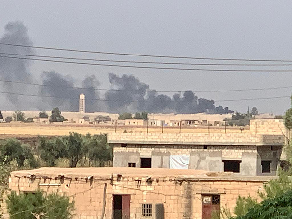 Dark smoke rises as the result of artillery strikes near Seri Kani, north of us.