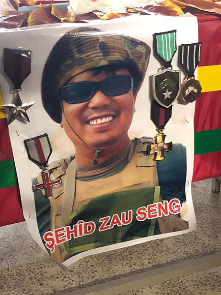 Zau's photo and medals on pinned to his coffin.