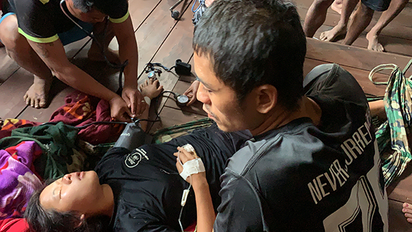 Toh, the director for the Jungle School of Medicine-Kawthoolei, inspects a patient as part of JSMK's medic-training program