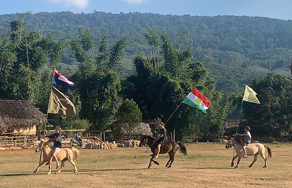 Suu, Sahale, and Peter ride in flags at the program