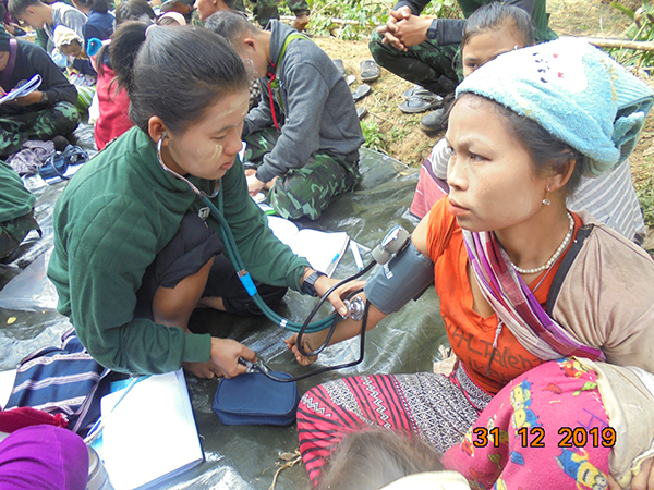 A medic checks the blood pressure of a local villager