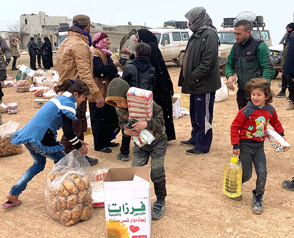 Families who fled Idlib receive food outside Manbij, Syria