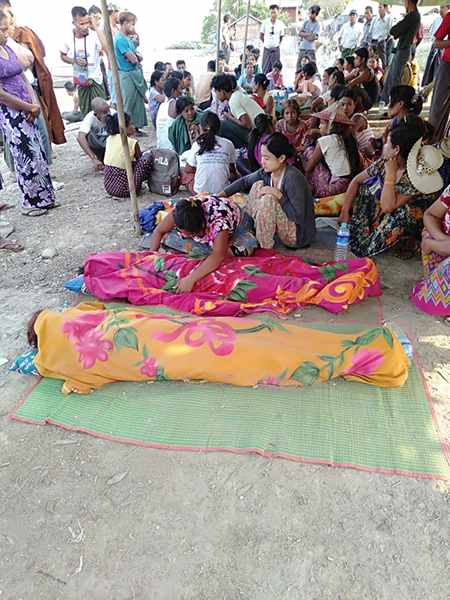 Villagers wrap up the bodies of the deceased