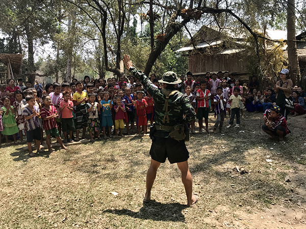 A Ranger teaches a song to villagers during a GLC program.