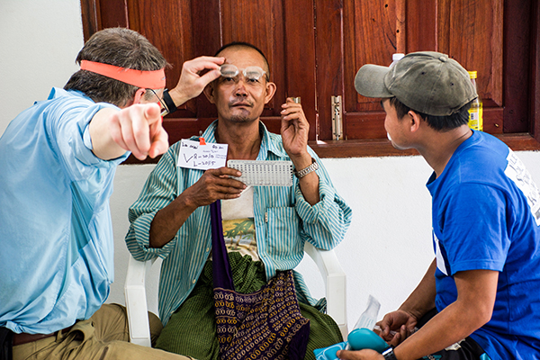 Hser Eh Too and Dr. Bob Arnold fit a Karen patient with reading glasses.