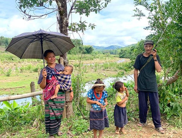 A family checks the radio for news of Burma Army movement near Ye Mu Plaw.