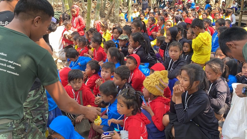 Arakan, Karenni and Karen team members give out snacks to the kids