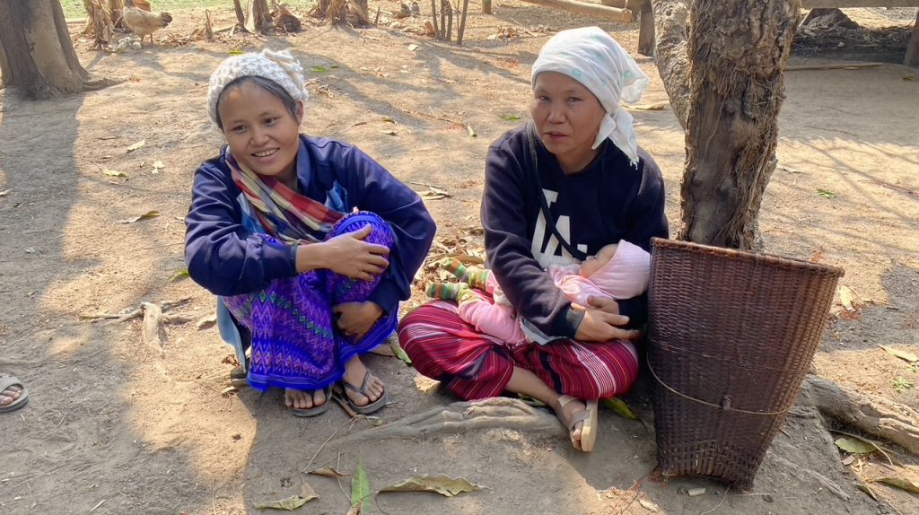 Displaced mothers watch their children have fun